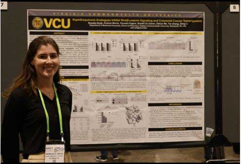 rosalie hoyle in front of a v.c.u. research poster